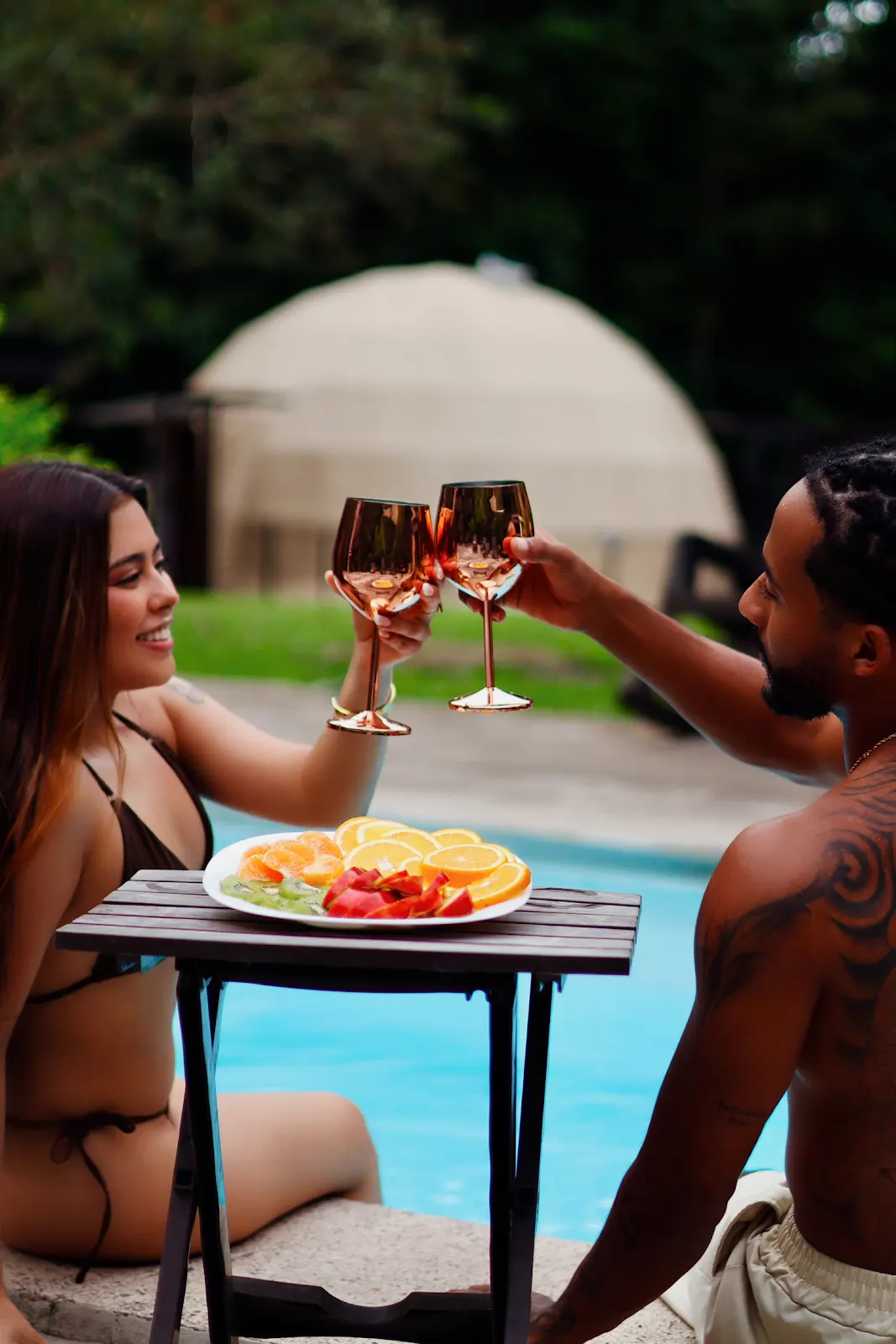 Pareja brindando junto a la piscina y los domos de Serenity
